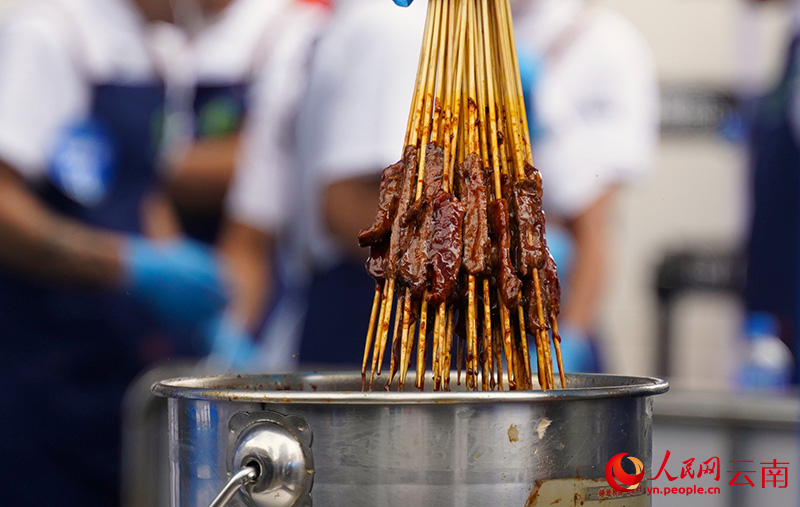 烤炙过程中蘸满酱料的昭通小肉串。 人民网记者 蔡树菁摄